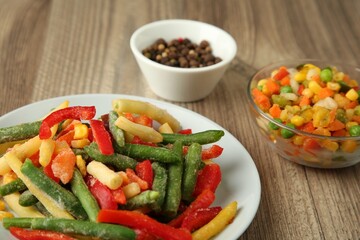 Mix of different frozen vegetables on wooden table, closeup