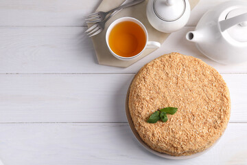 Delicious Napoleon cake served on white wooden table, flat lay. Space for text