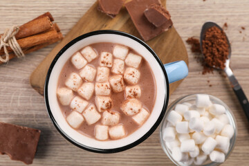 Obraz na płótnie Canvas Cup of aromatic hot chocolate with marshmallows and cocoa powder served on table, flat lay