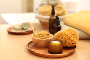 Dry flowers, loofah and jar with cream on wooden table indoors, space for text. Spa time
