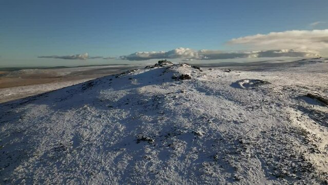 Aerial drone footage of Dartmoor covered by snow in winter, Yes Tor peak in the UK