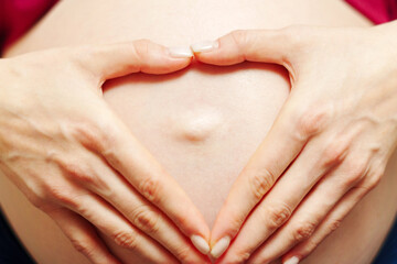 Pregnant woman holds her hands in her stomach. Third trimester. Pregnancy. Waiting for a miracle....