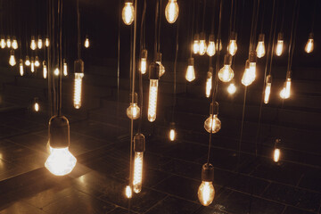 Incandescent light bulbs in a dark room. Lighting decor.