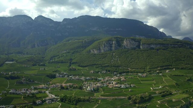 Aerial drone view of Cortaccia village and iconic church on the Alps mountain landscape region in Italy