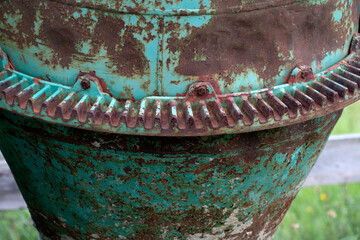 A rusty old cement mixer abandoned in a field