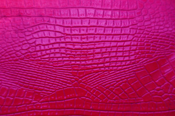 Vibrant violet, purple crocodile leather texture. pink crocodile skin artificial leather with waves and folds on PVC base. Alligator natural genuine bloody skin.