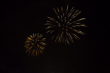 Golden fireworks on black background.