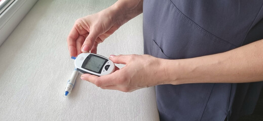 Close up shot of the glucometr instrument on the white surface. Healthcare