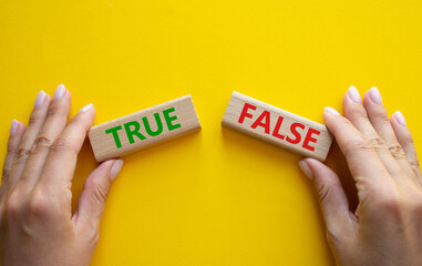 True or False symbol. Concept word True or False on wooden blocks. Businessman hand. Beautiful...