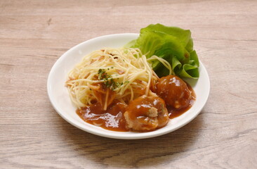 spaghetti dressing fried meatball stuffed cheese in ketchup sauce and cos lettuce on plate 