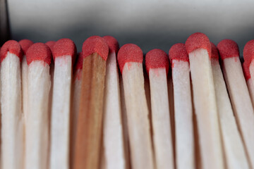 Lots of wooden matches with red sulfur heads closeup. Open box of matches. Matches in a cardboard...