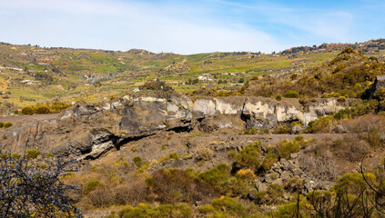 Fototapeta na wymiar Panoramic view of western slope of Mount Etna volcano with lava eruption formations in Bronte town over Simeto river valley in Catania region in Sicily, Italy