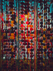 Beautiful multi-colored bead curtains under the lights.