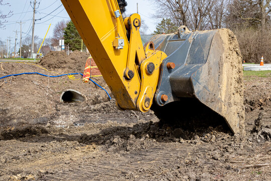 Bucket or scoop of excavator at road construction site. Infrastructure and earthmoving equipment maintenance, service and repair