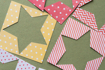 several machine-cut stencils with star shape cutouts on rough green paper
