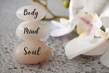 Obraz na płótnie Canvas Body, Mind and Soul text engraved on white zen stones Meditation and spa concept