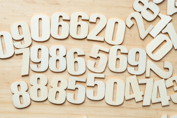 plain wood numbers arranged mostly randomly on a plain wooden surface