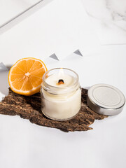 Fototapeta na wymiar Handmade candle in a glass. Scented candle for home with citrus aroma