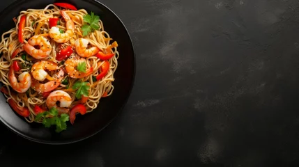 Tuinposter Spicy stir fried instant noodle with shrimps and thai basil leaves in black plate on dark marble . Top view © Werckmeister