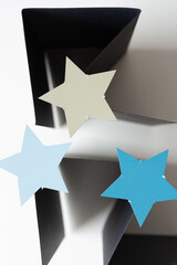 three paper stars on folded black paper (standing on edge) 