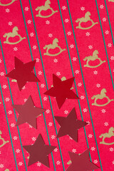 grungy red stars on vintage red wrapping paper with rocking horse and snowflake pattern