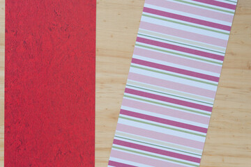 textured red and striped pink scrapbooking paper pieces on wood