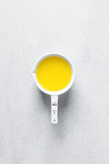 melted butter in white ceramic measuring cup