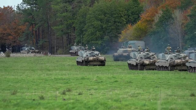 a squadron of British army Challenger 2 II FV4034 main battle tanks in action, moving out from a field on a military exercise. Wilts UK