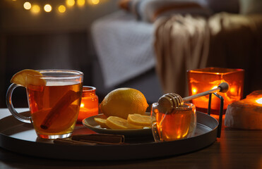 cup of tea with lemon and honey on wooden table at home