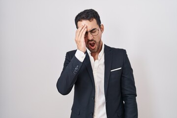 Handsome business hispanic man standing over white background yawning tired covering half face, eye and mouth with hand. face hurts in pain.
