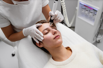 Obraz na płótnie Canvas A cosmetologist performs hydropiling in a beauty salon. Skin care.
