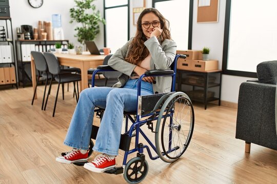 Young beautiful hispanic woman business worker smiling confident sitting on wheelchair at office