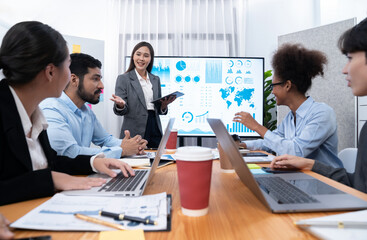 Young asian businesswoman presenting data analysis dashboard on TV screen in modern meeting. Business presentation with group of business people in conference room. Concord