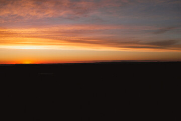 Red sunset on cloudy sky with silhouette