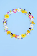 Spring Beltane floral wreath on blue background. Flower and wildflower garland for logo, menu, invitation, card for Mothers Day, anniversary, birthday, wedding day.