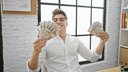 Confident young caucasian man, smiling business worker making it rain with dollars in the office