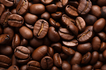 Fototapeta premium Close-up of freshly-roasted coffee beans in the foreground..Sumptuous shot of roasted coffee beans in the foreground..A sublime image of roasted coffee beans.