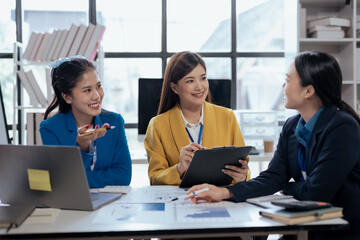 Team of young Asian businesswomen plan and meeting together and present marketing ideas in the office.