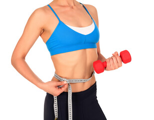 Closeup shot of slim young woman holding red dumbbell and measuring her thin waist with a tape...