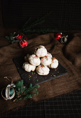 Profiteroles with white creme and christmas decoration on dark background. Vintage photo of tasty dessert - rustic style.