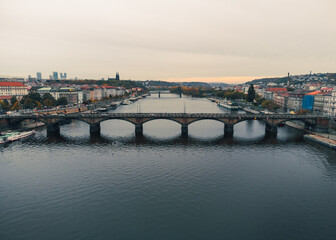 Obraz premium PRAGUE, CZECH - October 30, 2023: Aerial view of Prague city (Czech Republic) - famous bridges on Vltava river and old town in autumn time (Fall season). Prague from above on sunset - 