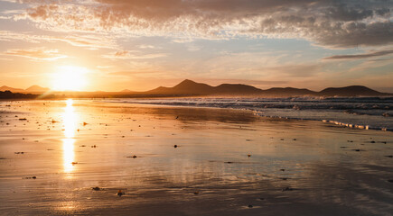Panoramic view of beautiful golden hour on the Famara. Beach in Lanzarote - Canary Islands.  Photo...