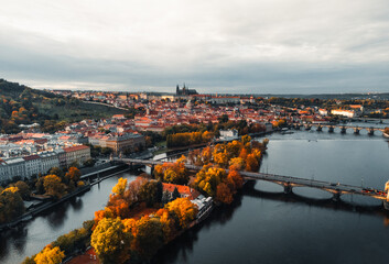 Aerial view of Prague city (Czech Republic) - famous bridges on Vltava river and old town in autumn time (Fall season). Prague from above during the sunset, taken by drone - cityscape concept.