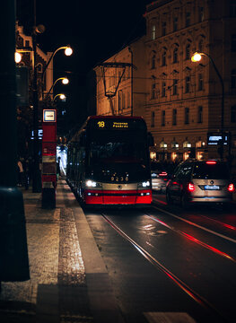 PRAGUE, CZECHIA - October 29, 2023: Vertical photo of red tram at night in Prague. Traffic in Prague at night. - car and tram.