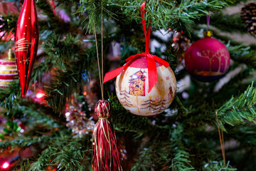 Festive christmas background. Multi-colored lights and balls on the branches of spruce. Blurry lights at night. Decorated Christmas tree on blurred background.