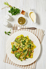ravioli primavera with ham on a white plate