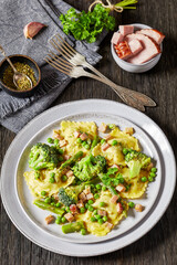 ravioli primavera with ham on a grey plate