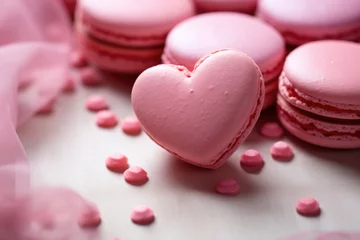 Tuinposter Macarons A pink macaron in the shape of a heart on a gentle gray textile