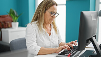Middle age hispanic woman business worker using computer working at the office