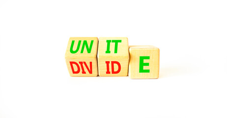 Unite or divide symbol. Concept word Unite or Divide on wooden cubes. Beautiful white table white background. Business unite or divide concept. Copy space.